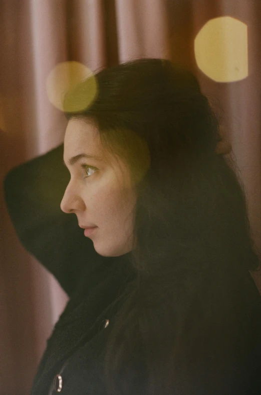 a women with green eyes looking out the window