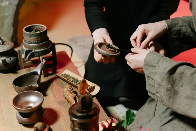 people holding spices over small bowl of soing