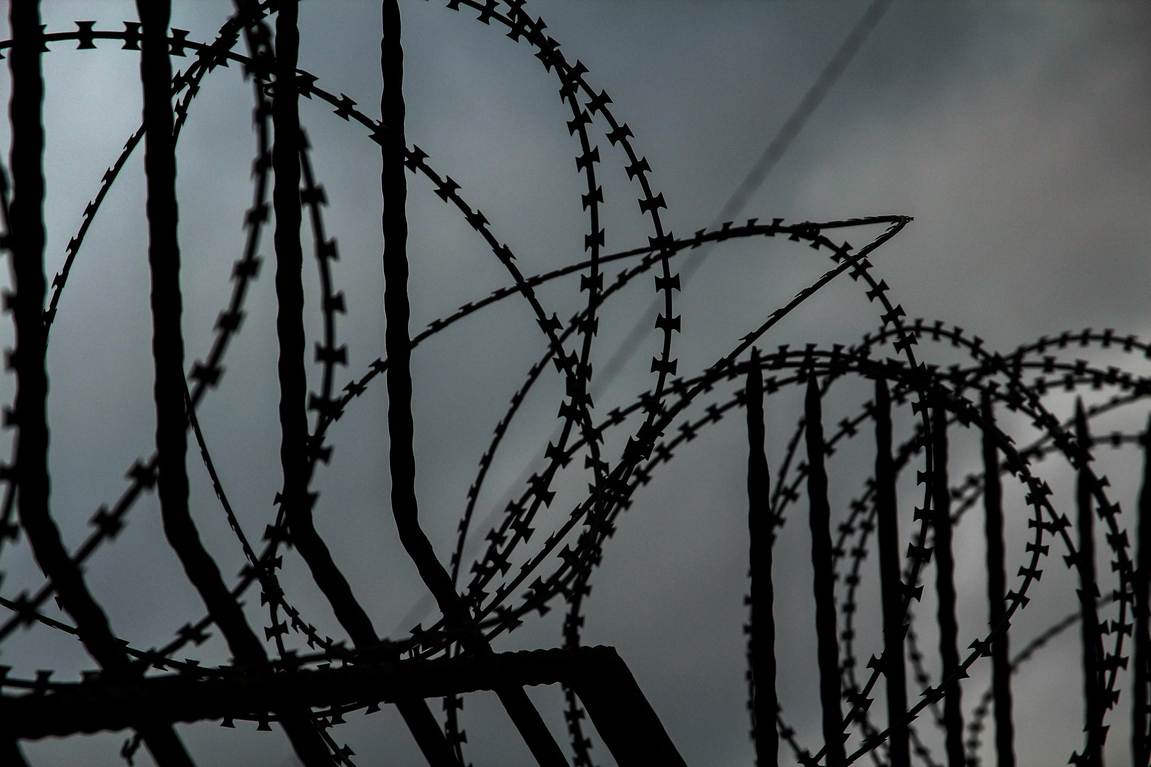 barbed wire surrounds the top of a fence