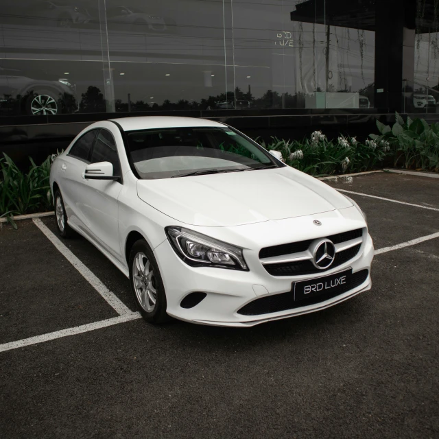 a white mercedes benz in a parking lot