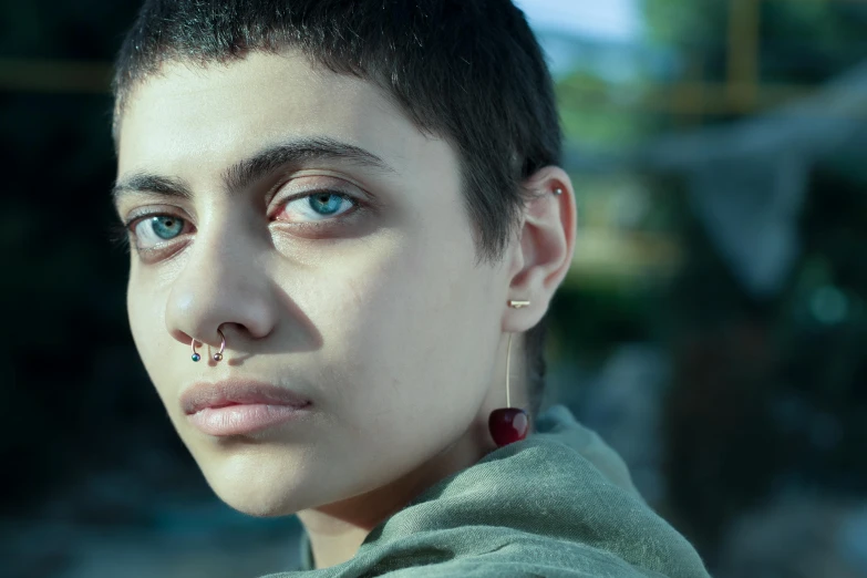 a woman wearing a green shirt looks at the camera