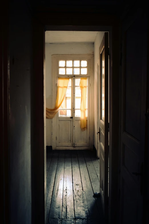 a white room with wood floor and bright yellow curtains