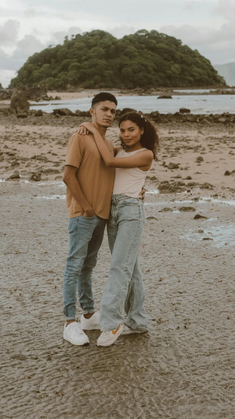 two people emcing on a beach by the water