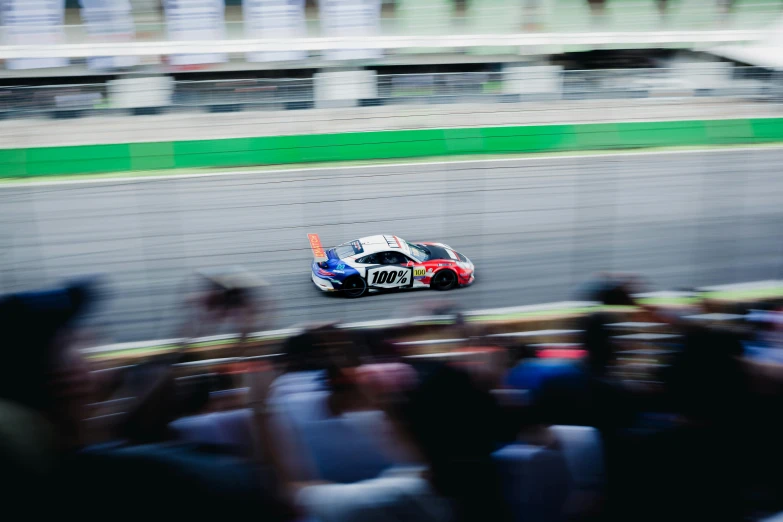 a group of people riding on the back of a racing car