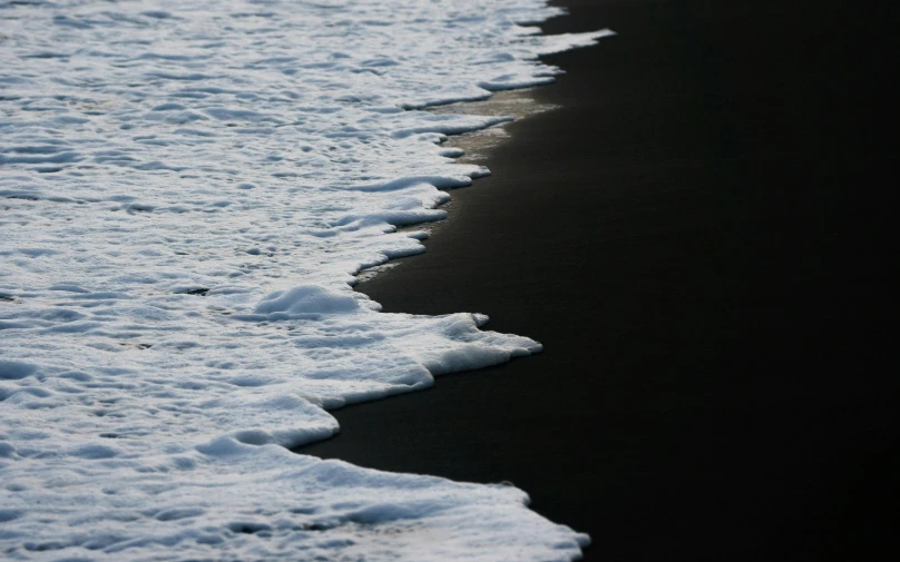 there is a black sand beach with waves lapping in the water