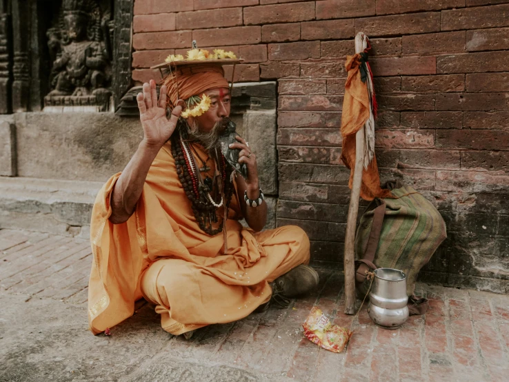 an old man in an orange outfit with a pipe and an indian headdress