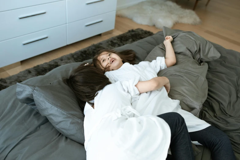 a man and a woman lying on their stomachs in bed