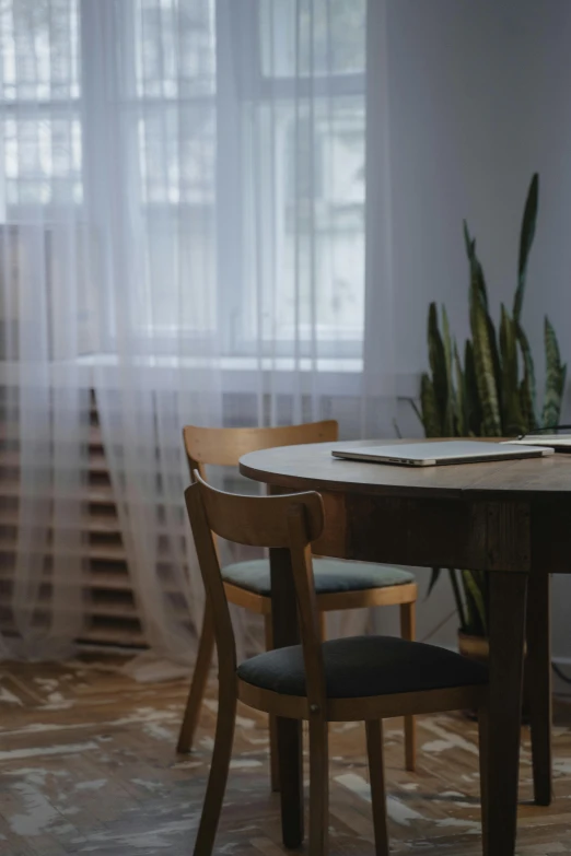 a dining room table and four chairs with papers on top