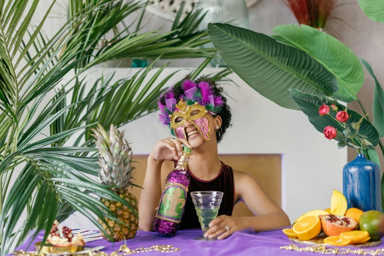 a girl sits at a table dressed in a purple, tropical costume