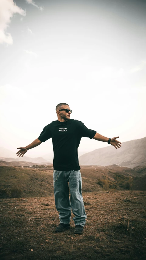 man in black shirt and jeans standing on brown field