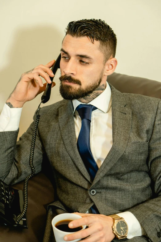 man with cup and coffee talks on the phone