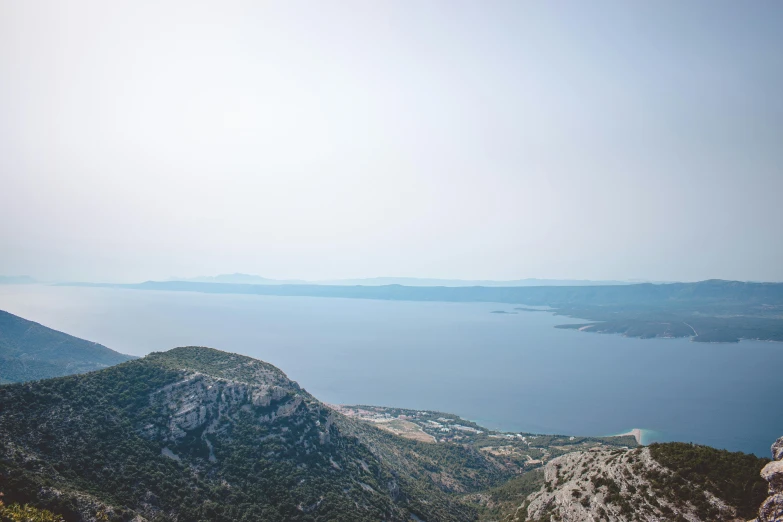 a man on top of a rock next to the ocean