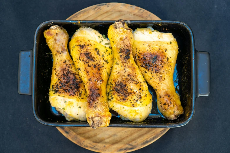 chicken legs and broiled end sit in an oven dish