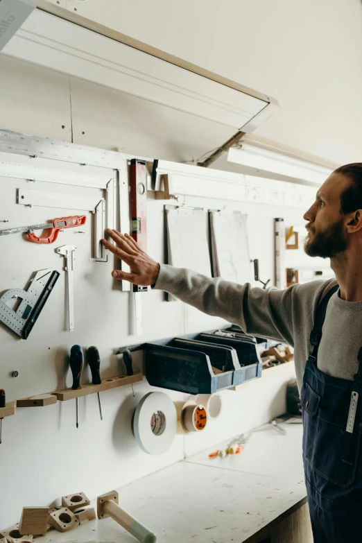 a man is looking at different tools on the wall