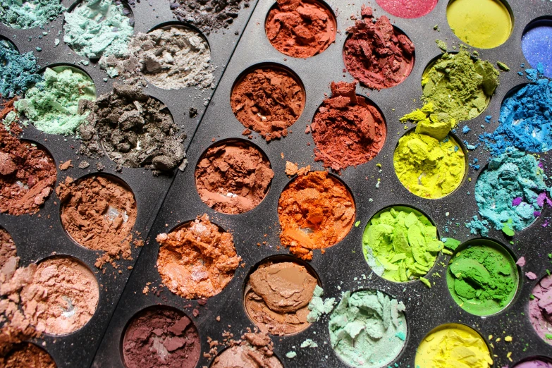 a bunch of different colored powders are on the tray