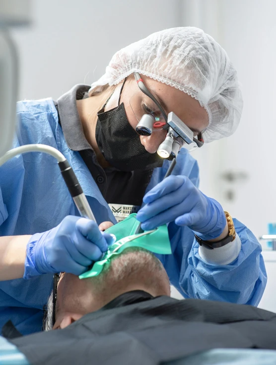 a man is wearing gloves and having his teeth brushed