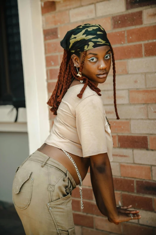 a woman in shorts and t - shirt near a brick wall