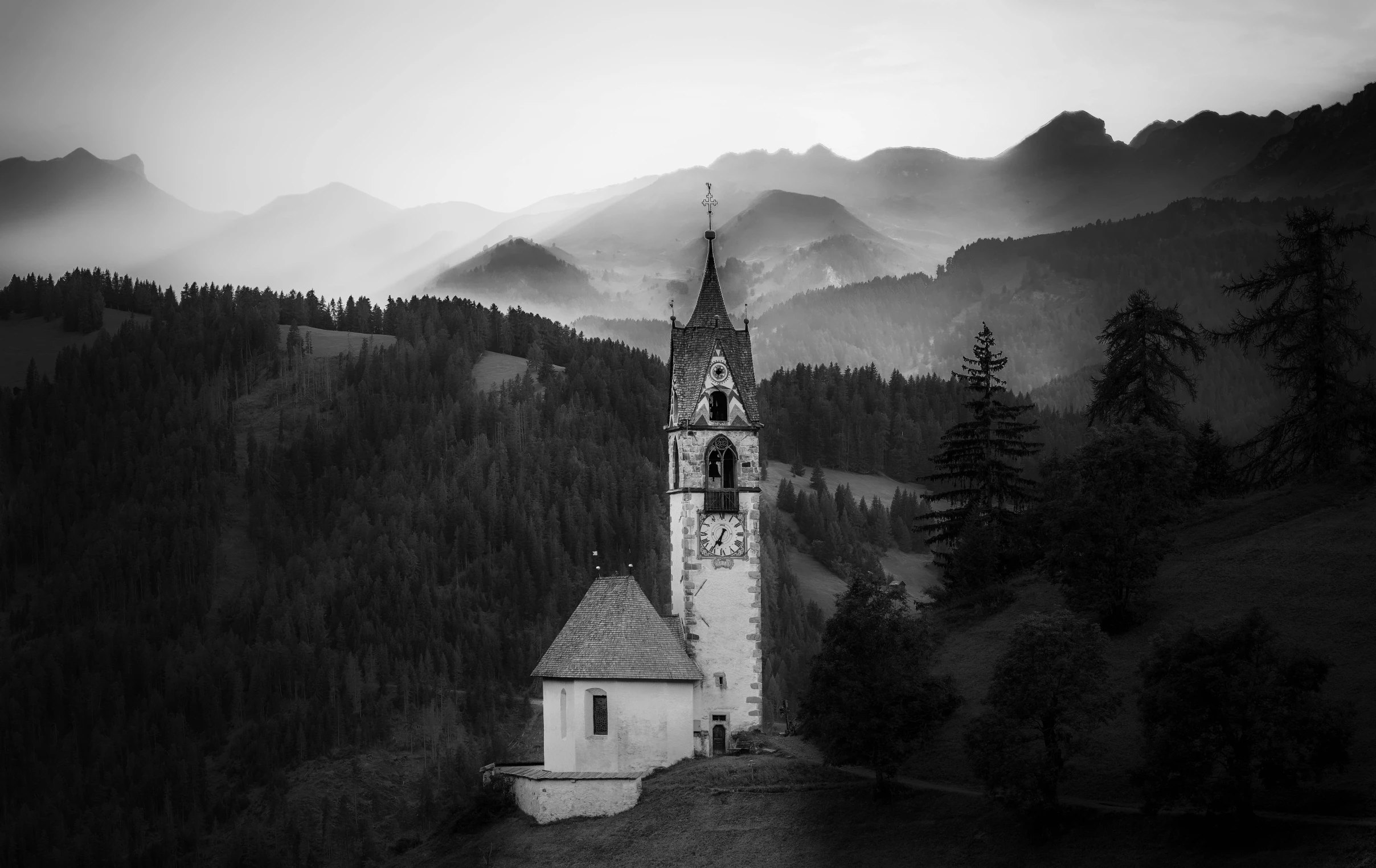 a building sitting on top of a mountain next to trees