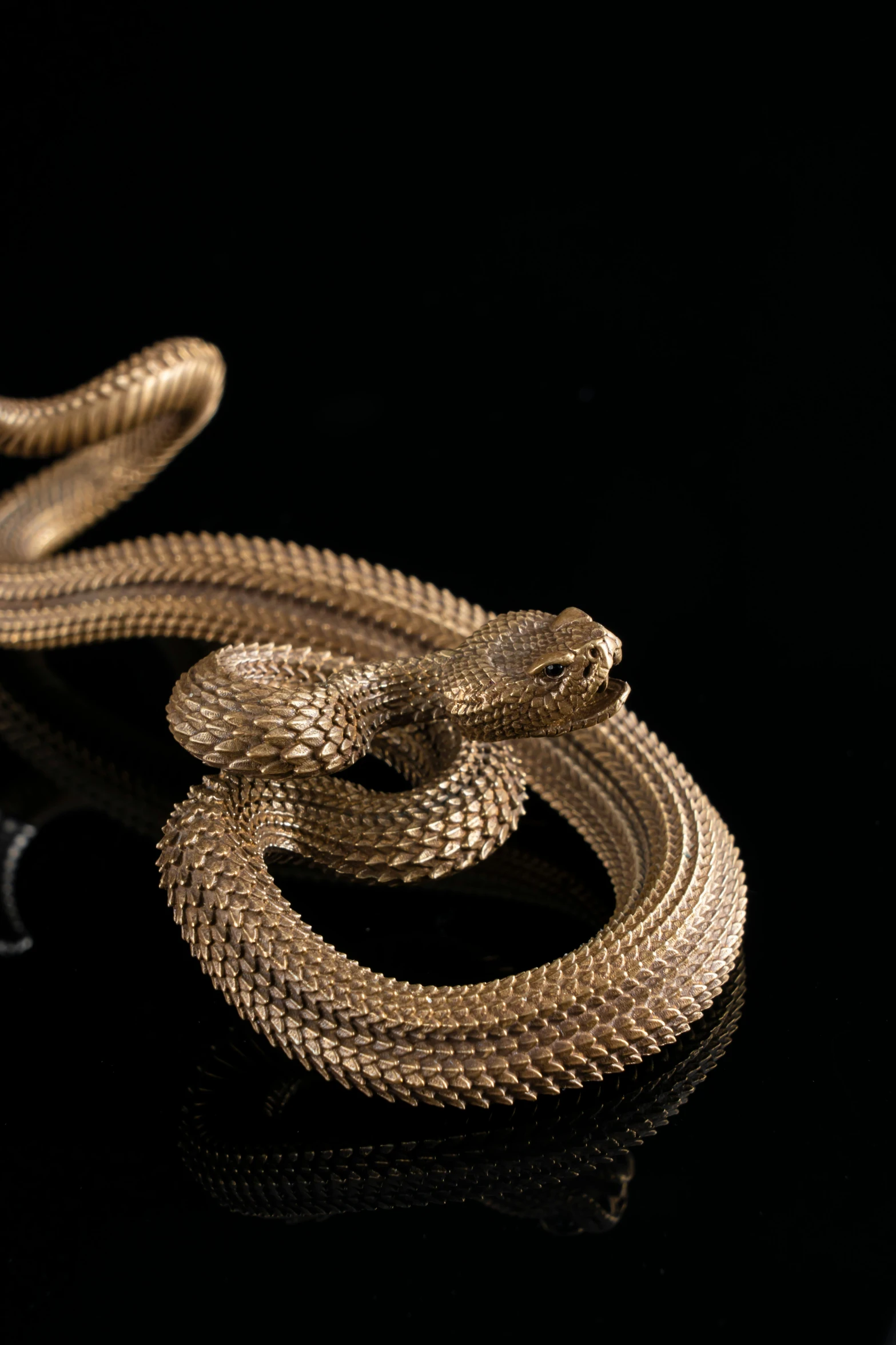 an artistic golden snake on a black surface