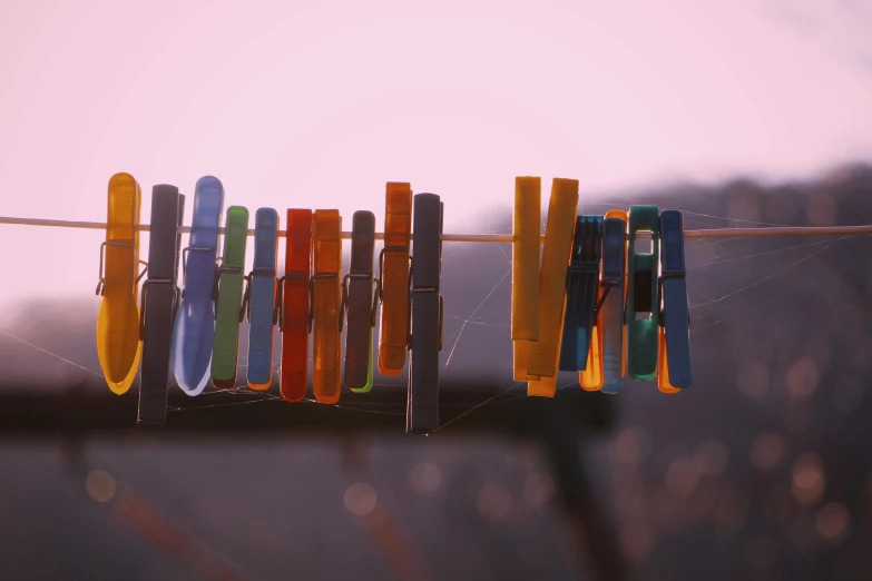 a group of clothes pins hanging on a clothes line