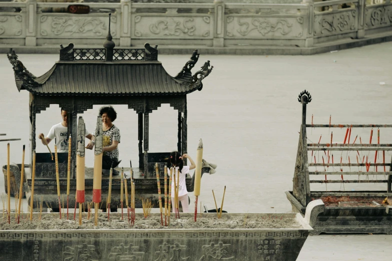 an asian man talking to a woman near a pagoda