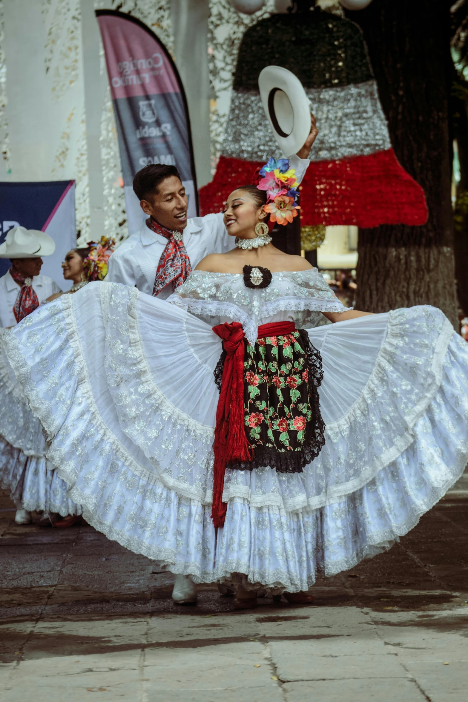 two men and a woman in traditional mexican clothes are holding their arms behind her as they dance