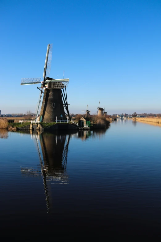 a windmill in a lake near a bunch of other small boats