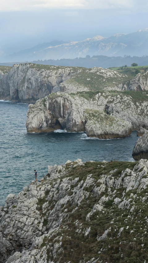 the hikers look out at the ocean and cliffs