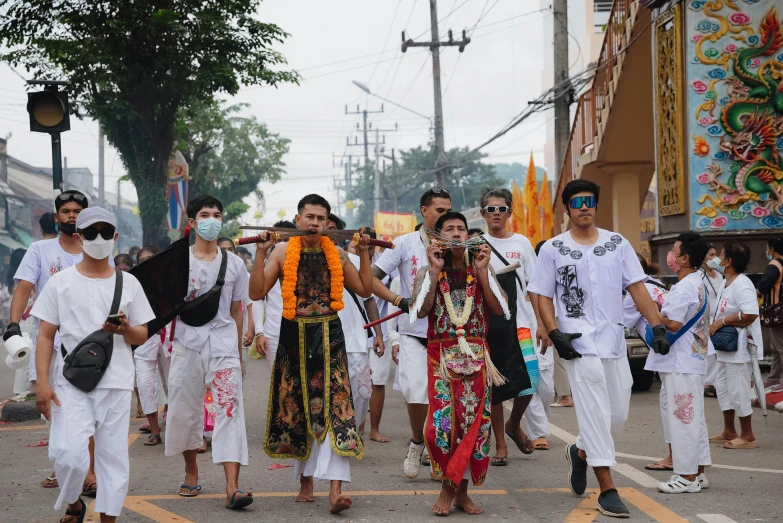 people wearing traditional attire are crossing the street