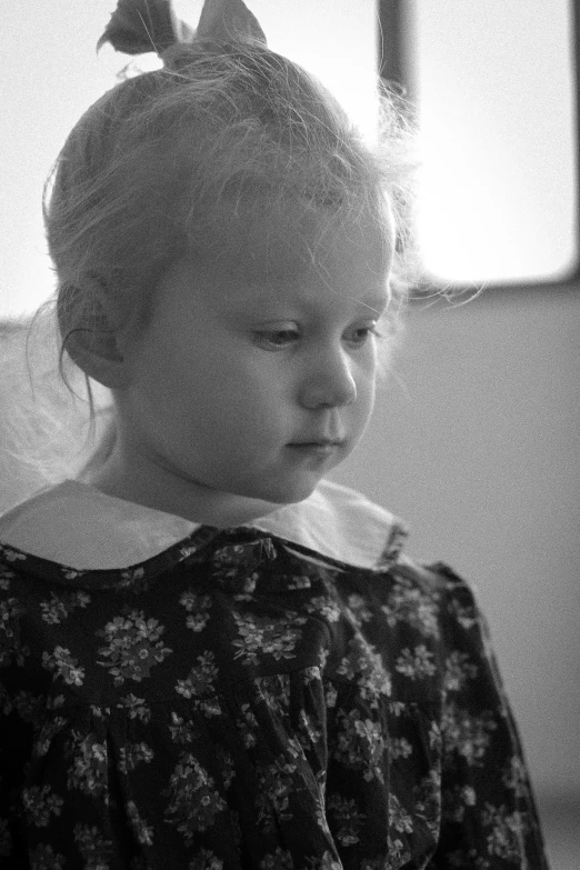 a woman sitting and looking at soing with an untidy hairdo