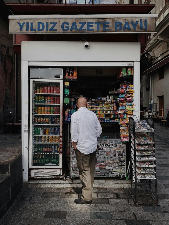 man looking in window to purchase goods at store