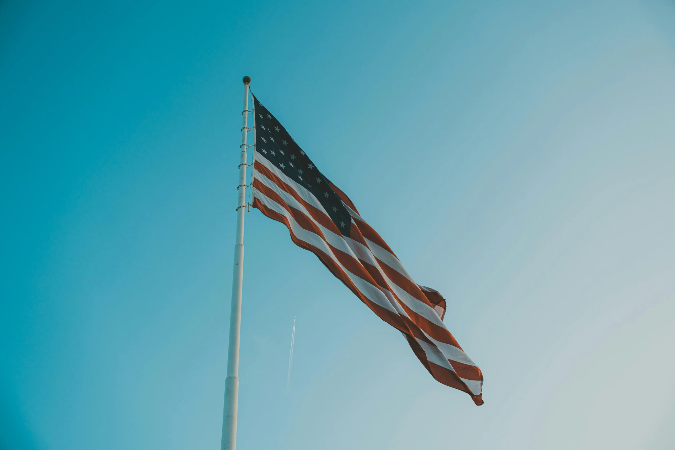 an american flag blowing in the wind on a clear day