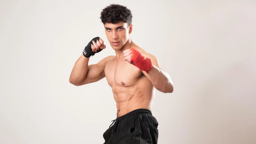 a man in boxers and boxing gloves standing with one arm raised