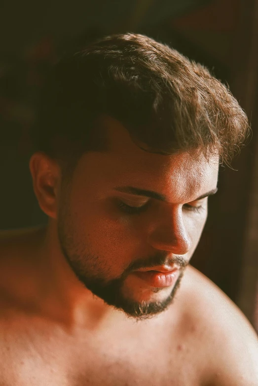 a shirtless man with his eyes closed next to a piece of bread