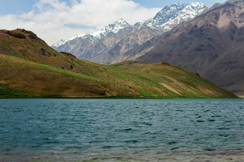 water in front of mountain peaks near a body of water