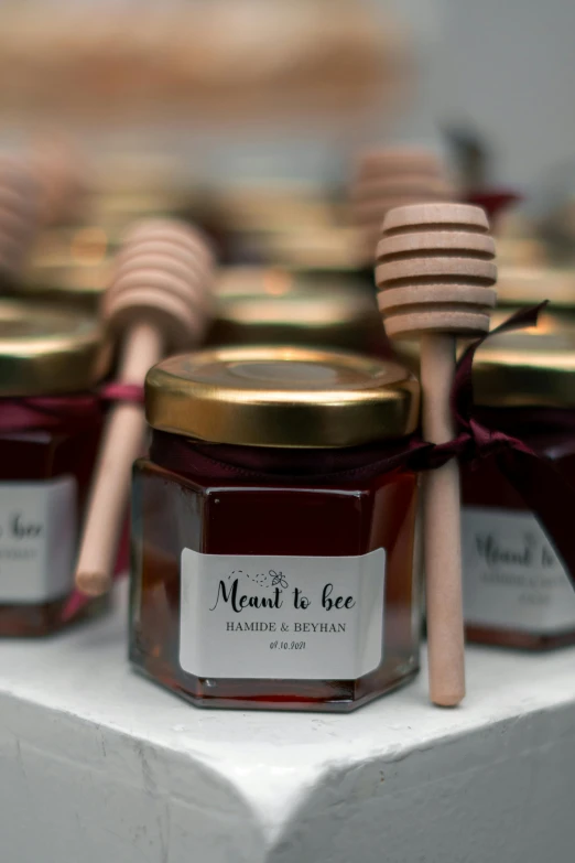 some honey and spoons on a white shelf