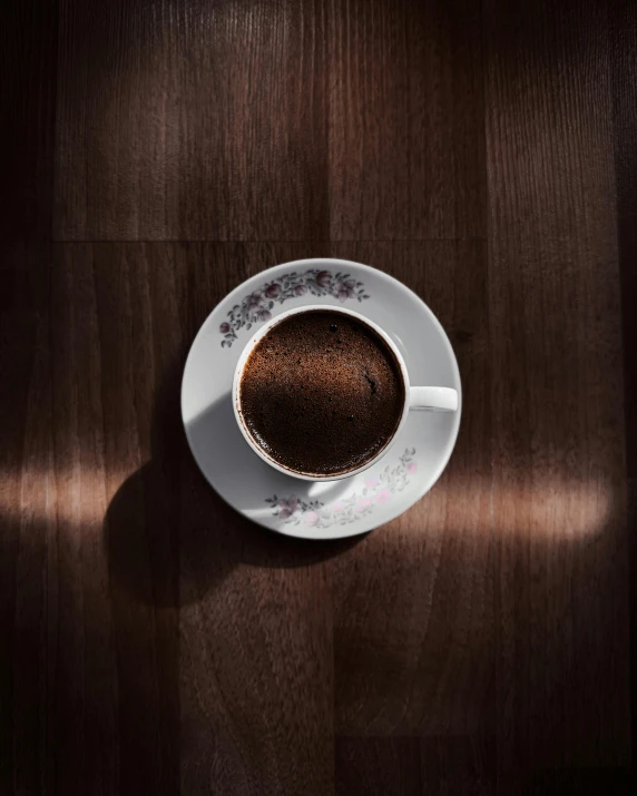 a cup of coffee with an elevated view of its reflection