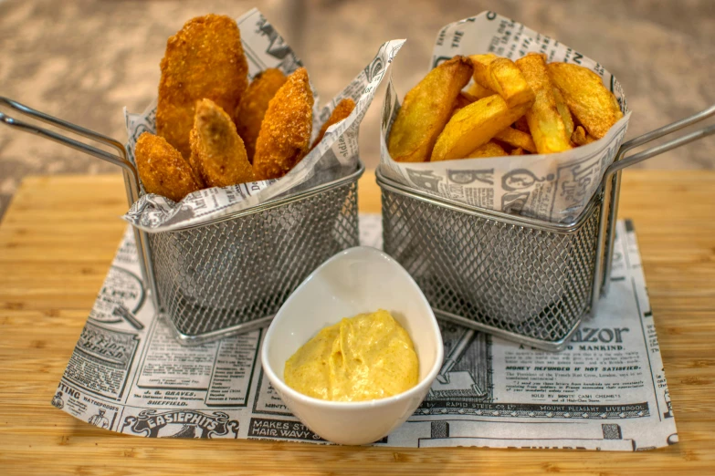 two baskets filled with french fries on top of a paper
