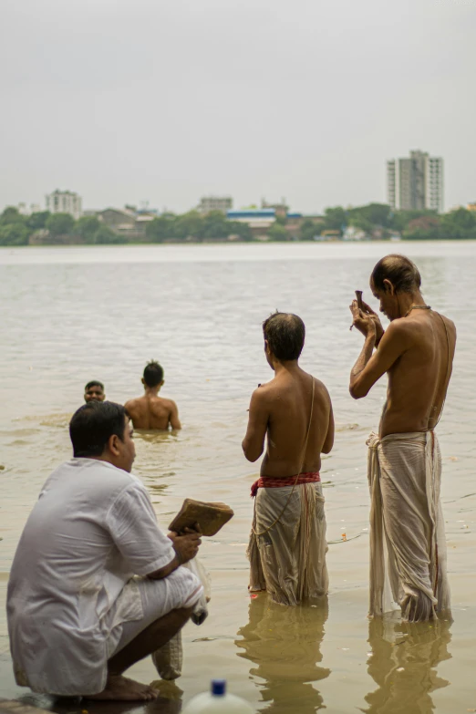 men are sitting in the water and watching soing