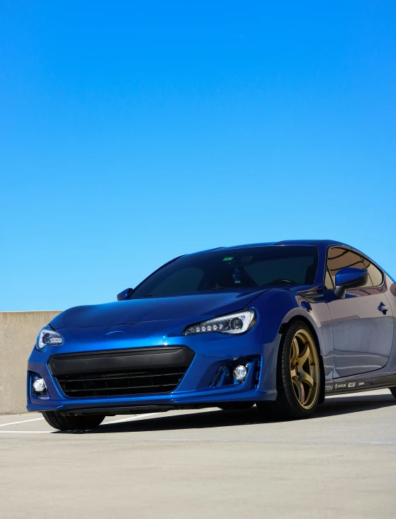 a blue car sits parked on the cement