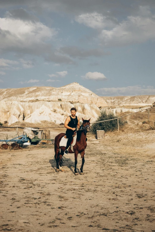 the man rides a horse in the desert