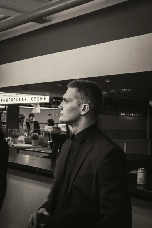 black and white pograph of a man standing at an indoor restaurant