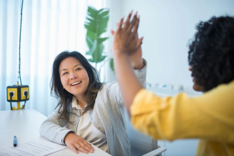 two asian women sitting at a white table