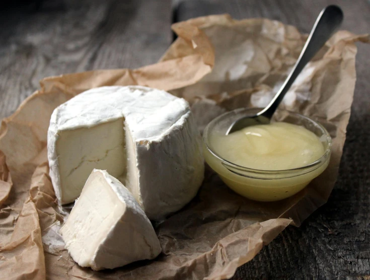 a piece of cheese, er and a container on a table