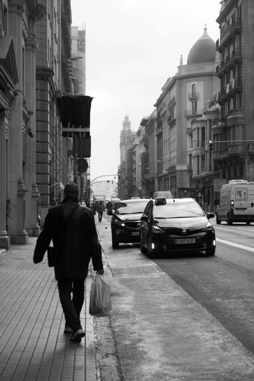 a man is walking on the sidewalk in front of the traffic