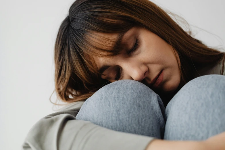 a woman holding her face to her chest