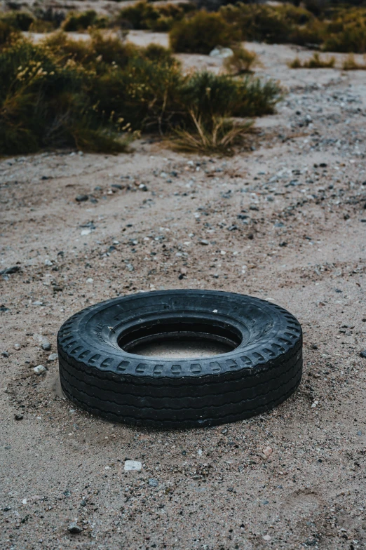 a tire that is sitting on some sand