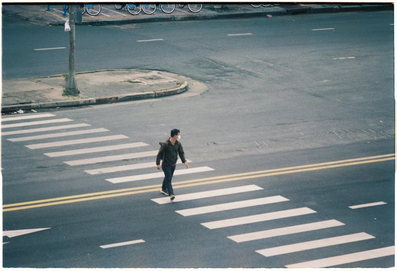 a person is crossing the street in the middle of the day