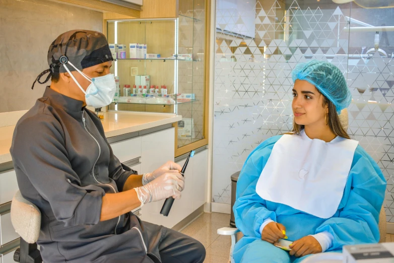 the female surgeon is showing her patient how to use her digital tablet