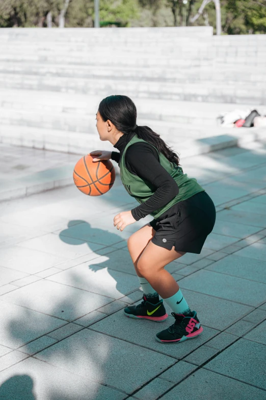 a woman holding a basketball while standing on a court